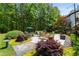 Secluded backyard with a patio, fire pit, outdoor seating, mature trees, and beautiful landscaping creating a private oasis at 12815 Oak Falls Dr, Alpharetta, GA 30009