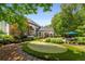 Expansive backyard with putting green, large deck, lush landscaping, and patio seating area perfect for entertaining at 12815 Oak Falls Dr, Alpharetta, GA 30009