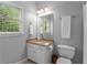 Cozy bathroom features a granite countertop, white cabinets, and natural light from a window at 12815 Oak Falls Dr, Alpharetta, GA 30009