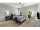 Light-filled bedroom features large windows, a desk, ceiling fan and ample space for furniture at 12815 Oak Falls Dr, Alpharetta, GA 30009