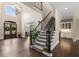 Elegant foyer features hardwood floors, a staircase, and a chandelier with abundant natural light at 12815 Oak Falls Dr, Alpharetta, GA 30009