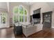 Bright living room with large windows, dark wood floors and built-in shelving around the fireplace at 12815 Oak Falls Dr, Alpharetta, GA 30009