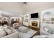 Bright living room features a fireplace, built-in bookshelves, and seamless flow into the modern kitchen at 12815 Oak Falls Dr, Alpharetta, GA 30009