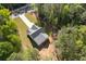 An aerial view of a modern gray-roofed home nestled amongst lush green trees and a long driveway at 1488 Campbell Rd, Covington, GA 30014