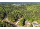 Sweeping aerial shot reveals home in lush surroundings near a winding road and distant lake at 1488 Campbell Rd, Covington, GA 30014