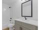 Bathroom features white vanity, large mirror, and shower-tub combo at 1488 Campbell Rd, Covington, GA 30014