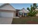 Charming brick home featuring a manicured lawn, two-car garage, and eye-catching architectural details at 710 Park Place Trl, Social Circle, GA 30025