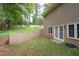 Partial view of a private backyard featuring a retaining wall, grassy area, and sliding glass doors at 1593 Brynwood Nw Ct, Acworth, GA 30101