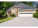 Charming home featuring a stone facade, well-manicured lawn, and a two-car garage with a grey shingled roof at 1593 Brynwood Nw Ct, Acworth, GA 30101