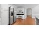 Open kitchen with stainless steel refrigerator, granite countertops, white cabinets, and hardwood floors at 1593 Brynwood Nw Ct, Acworth, GA 30101