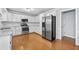 Bright kitchen featuring stainless steel appliances, white cabinets, granite countertops, and hardwood floors at 1593 Brynwood Nw Ct, Acworth, GA 30101