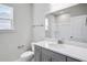 Bathroom featuring a gray vanity, bright white countertop, shower, and natural light from the window at 464 Village Ln, Fairburn, GA 30213