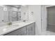 Modern bathroom with double vanity, marble countertops and walk-in shower with glass door at 464 Village Ln, Fairburn, GA 30213