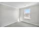Bright bedroom featuring a window offering natural light, neutral carpet, and base trim at 464 Village Ln, Fairburn, GA 30213
