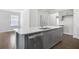 Modern kitchen with stainless steel appliances, island, and gray cabinets at 464 Village Ln, Fairburn, GA 30213