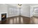Bright living room with fireplace, ceiling fan, and large windows overlooking the backyard at 464 Village Ln, Fairburn, GA 30213