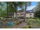 Multi-story home showcasing a lush backyard with mature trees, manicured landscaping, and patio area at 170 Elysian Nw Way, Atlanta, GA 30327