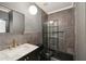 Modern bathroom with marble vanity top, sleek gold faucet, and stylish glass-enclosed shower with dark tiling at 1888 Sever Creek Cir, Lawrenceville, GA 30043