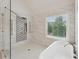 Luxurious bathroom featuring a freestanding tub, shower, and a large window offering natural light at 1888 Sever Creek Cir, Lawrenceville, GA 30043