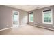 Spacious bedroom with plush carpeting, tray ceilings, and windows offering natural light at 1976 Glen Echo Dr, Decatur, GA 30032
