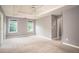 Large bedroom featuring soft carpet, tray ceilings, and windows for natural light at 1976 Glen Echo Dr, Decatur, GA 30032