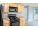 Well-equipped kitchen with black appliances, wooden cabinets, and a neutral countertop at 1976 Glen Echo Dr, Decatur, GA 30032
