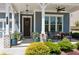 Cozy front porch with seating area, decorative plants, and charming details like hanging lights and wreath at 4207 N Carver Dr, Atlanta, GA 30360