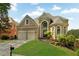 Beautiful brick home with a well-manicured lawn, two-car garage, and stunning architectural details at 5335 Davenport Mnr, Cumming, GA 30041