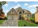 Traditional brick home with two-car garage, arched entry, and manicured front lawn at 5335 Davenport Mnr, Cumming, GA 30041