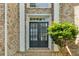 Inviting front entrance featuring double doors flanked by brick columns and lush greenery at 5335 Davenport Mnr, Cumming, GA 30041