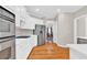 A spacious kitchen with stainless steel appliances, white cabinets, and hardwood flooring at 5335 Davenport Mnr, Cumming, GA 30041