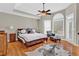 A spacious main bedroom with a ceiling fan, large windows, and hardwood floors at 5335 Davenport Mnr, Cumming, GA 30041