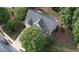 Aerial view of home showcasing roof, driveway, and surrounding mature trees at 6131 Windflower Dr, Powder Springs, GA 30127