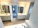 Bright primary bathroom features double sinks, tile floors, and large mirrors at 6131 Windflower Dr, Powder Springs, GA 30127