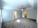 Spacious bedroom featuring neutral walls, carpeted floors, a ceiling fan, and natural lighting at 6131 Windflower Dr, Powder Springs, GA 30127