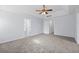Large bedroom with tray ceilings, carpet floors, ceiling fan, and multiple entry doors at 6131 Windflower Dr, Powder Springs, GA 30127