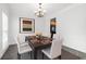 Formal dining room with modern decor, including a chandelier and table for four at 6131 Windflower Dr, Powder Springs, GA 30127