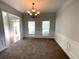 Inviting dining room with chandelier, chair rail, and large windows providing ample natural light at 6131 Windflower Dr, Powder Springs, GA 30127