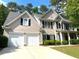 Charming home featuring a two-car garage, manicured shrubs, and a well-maintained front lawn at 6131 Windflower Dr, Powder Springs, GA 30127