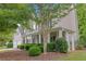 Low angle view of the home featuring the front yard, landscaping, and front porch with columns at 6131 Windflower Dr, Powder Springs, GA 30127