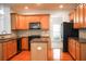 Functional kitchen featuring wood cabinets, granite countertops, and black appliances at 6131 Windflower Dr, Powder Springs, GA 30127