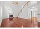 Open-concept living room with hardwood floors, fireplace, and a staircase leading to the second floor at 6131 Windflower Dr, Powder Springs, GA 30127