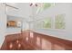 Bright, open living area with hardwood flooring, soaring ceilings, large windows, and an adjacent kitchen at 6131 Windflower Dr, Powder Springs, GA 30127