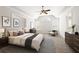 Bright and spacious primary bedroom with tray ceiling, ceiling fan, and comfortable seating area at 6131 Windflower Dr, Powder Springs, GA 30127