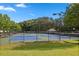 A community tennis court surrounded by a fence and greenery at 6131 Windflower Dr, Powder Springs, GA 30127