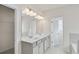 Bright bathroom with dual sinks, white cabinetry, and decorative lighting at 1215 Elowen Dr, Austell, GA 30168