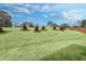 Exterior front yard featuring a landscaped area with newly installed sod, trees, and mulch at 1215 Elowen Dr, Austell, GA 30168