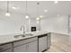 Open kitchen with gray cabinets, stainless steel appliances, pendant lighting and granite countertops at 1215 Elowen Dr, Austell, GA 30168