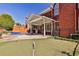 Backyard showcasing a putting green, pool, brick house, and covered patio with an outdoor dining set at 389 Mill Creek Ne Bnd, Atlanta, GA 30307