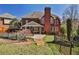 View of backyard with a brick house, putting green, pool, covered patio, and a fenced-in yard at 389 Mill Creek Ne Bnd, Atlanta, GA 30307